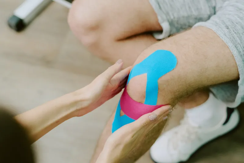 KT Tape applied to a knee to relieve Osgood pain in an adult